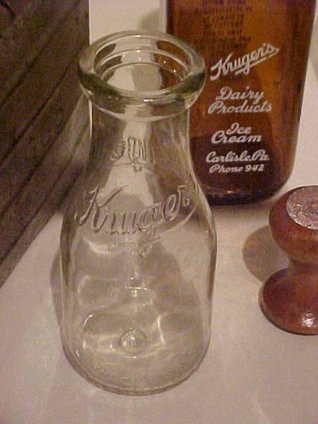 Image of Clear milk bottle, embossed with "Kruger's".