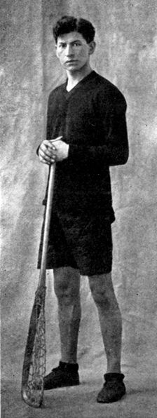 Edward Bracklin, Captain of LaCrosse Team in uniform holding LaCrosse stick.