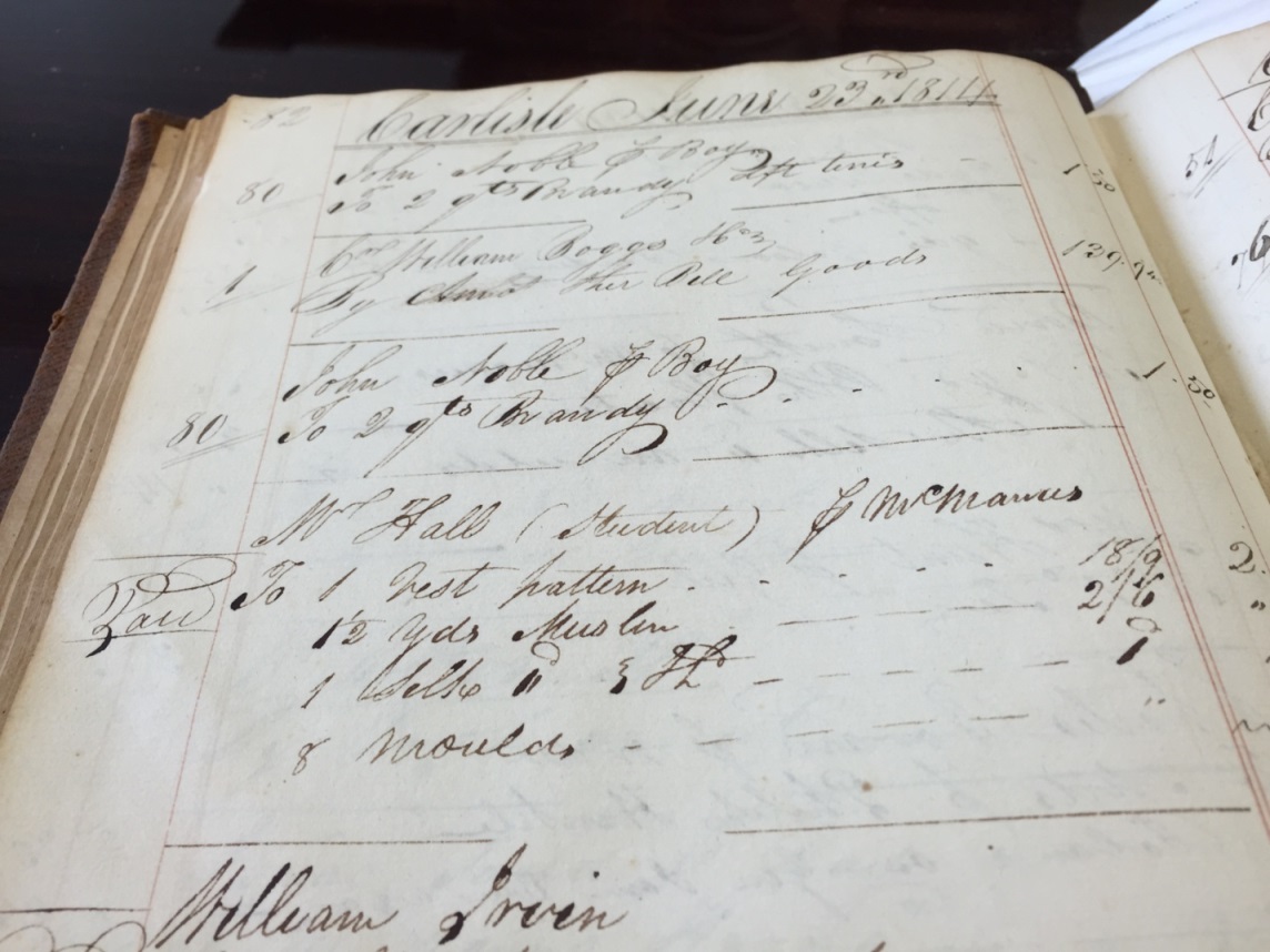 Photo of a page from a Carlisle merchant’s Day Book, dated June 23, 1814, showing that Cormick McManus charged a vest pattern, 1 ½ yards of muslin, silk and eight (button) moulds to make a vest for Mr. Hall, a student at Dickinson College.