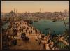 Print shows a bird's-eye view of many pedestrians and a horse-drawn carriage on the Galata Bridge, which spans the Golden Horn at Eminönü, Istanbul, Turkey, with minarets and mosques visible in the background
